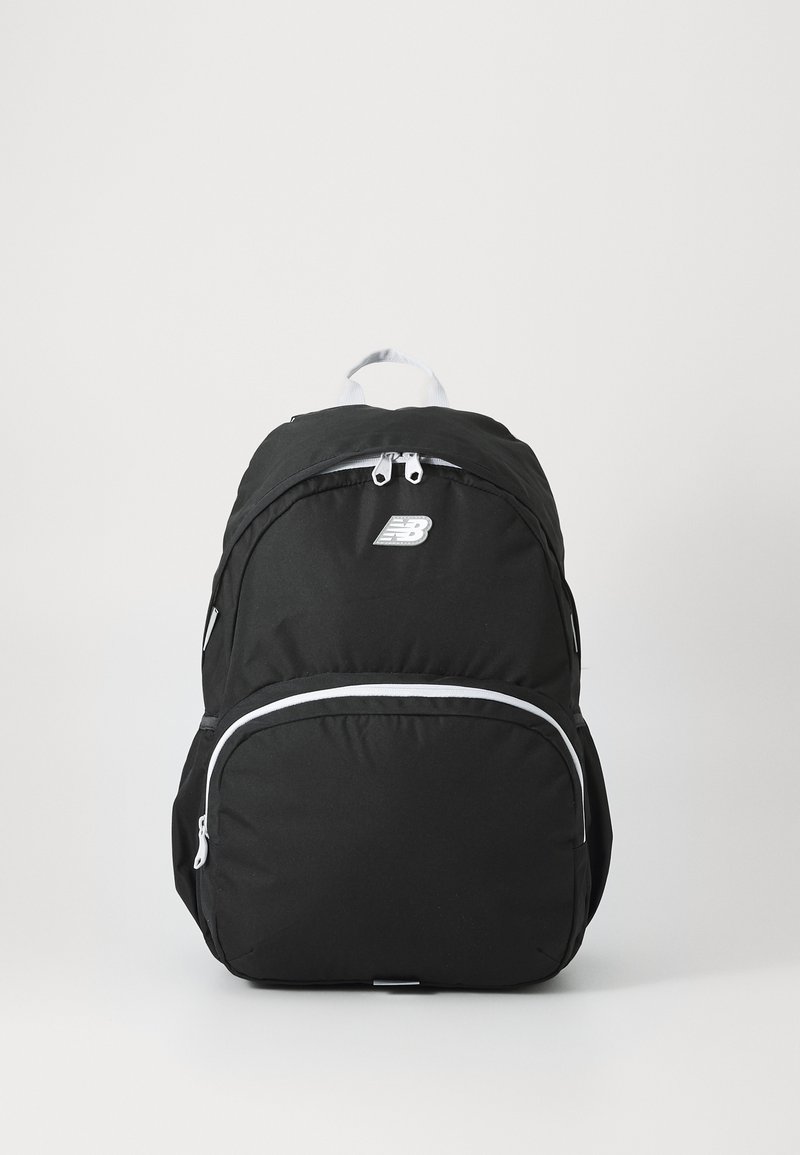 Mochila preta com forma arredondada, feita de tecido durável. Apresenta um bolso frontal com zíperes brancos e um pequeno logotipo na parte de cima.