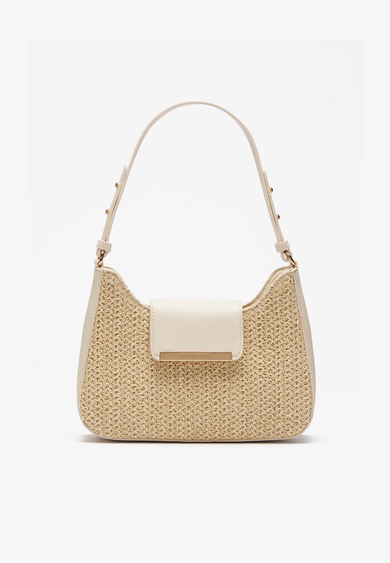 Beige handbag with woven textured body, smooth cream flap, and a short strap. Gold hardware accent adds detail to the design.