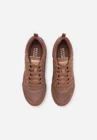 Brown athletic shoes with a mesh and suede upper, round toe, padded tongue, and matching laces. Features a textured rubber sole.