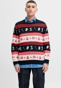 Suéter de punto en negro, rojo y crema con patrones navideños que incluyen árboles, regalos, muñecos de nieve y bastones de caramelo. Puños y dobladillo acanalados.