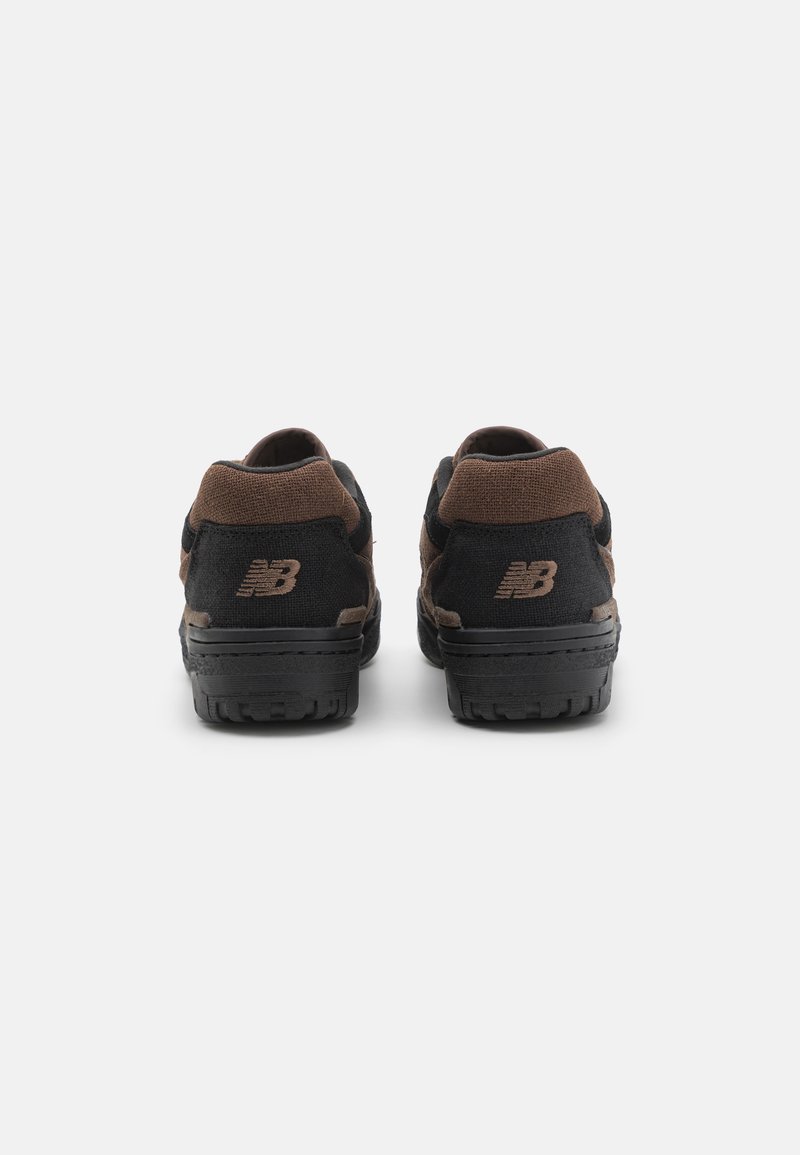 Zapatillas negras y marrones con parte superior de ante y malla, que cuentan con una suela texturizada y un detalle de marca en la parte trasera.
