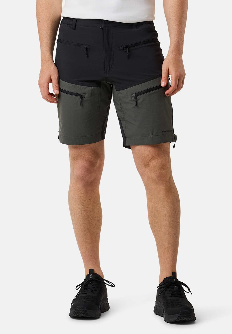Zwarte en groene shorts met meerdere met rits afgesloten zakken, gemaakt van lichtgewicht materiaal, met een moderne pasvorm en korte lengte.