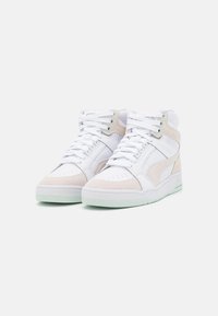 High-top sneakers featuring white leather and light beige suede, with padded collar, lace-up front, and mint-green rubber sole.
