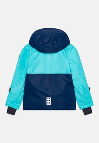 Hoodie med en design som har ljusblå och marinblåa färgblock, slät textur och en vit accent med sex cirkulära utskärningar på baksidan.