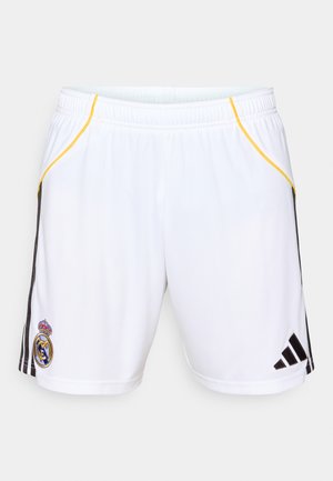 Białe szorty sportowe z czarnymi paskami po bokach i żółtymi akcentami, z haftowanym emblematem na lewej nodze i elastycznym pasem.