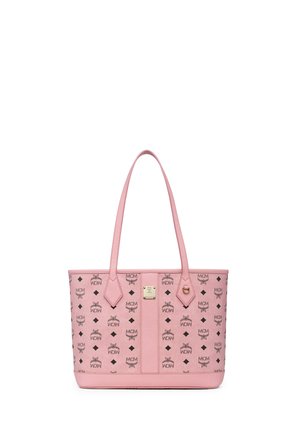 Różowa torba typu tote z długimi rączkami, czarny wzór z logo MCM oraz mała złota metalowa plakietka na środku przedniego panelu.