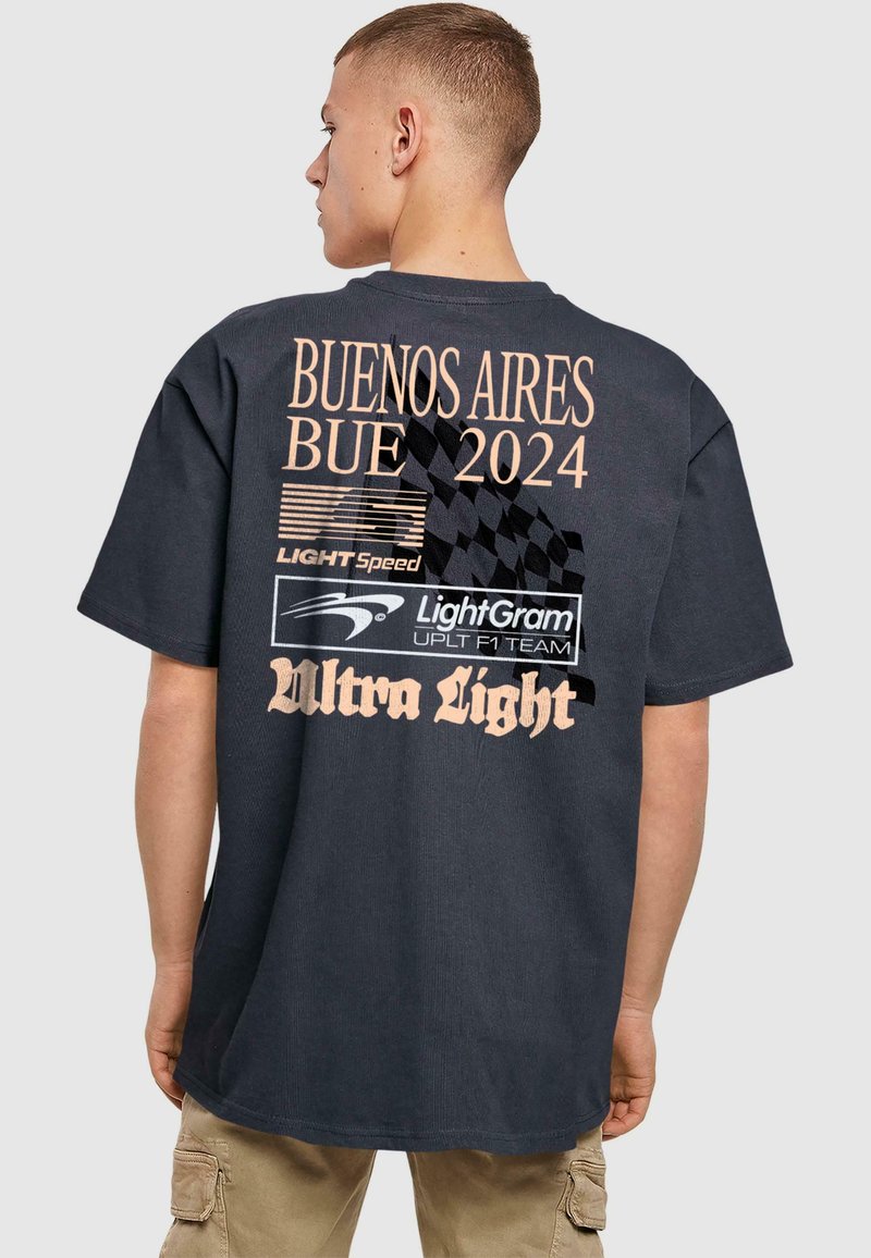Cămașă neagră din bumbac, cu un design grafic pe spate ce conține textul "BUENOS AIRES BUE 2024" în nuanță de bej, alături de mai multe logo-uri și un model căptușit.