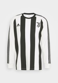 Langærmet trøje med sort og hvid lodret strib, adidas-branding og et Juventus-logo på venstre bryst. Materialet er i bomuld.