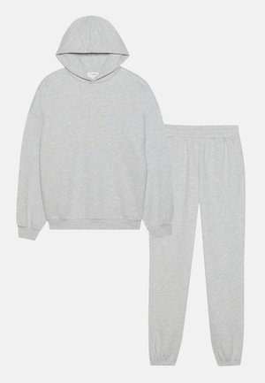 Haut en polaire gris avec une poche kangourou et un pantalon de survêtement assorti, doté d'une taille élastique et de poignets, en matériau doux en mélange de coton.