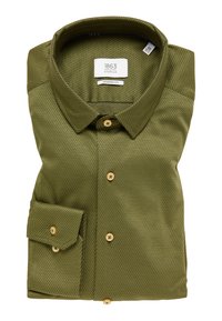 Camicetta verde oliva in una vestibilità moderna, con un motivo testurizzato, colletto a punta e bottoni marrone chiaro. Sono visibili le maniche arrotolate.