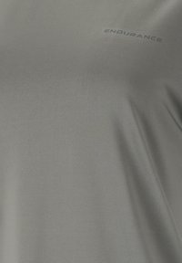 Graues Sport-T-Shirt aus glattem, leichtem Stoff. Die Worte "ENDURANCE" sind in einem dunkleren Farbton nahe dem Rundhalsausschnitt aufgedruckt.