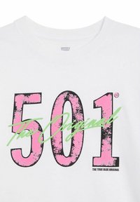 Bílý bavlněný tričko s výrazným, opotřebovaným černým a růžovým textem "501" a zeleným nápisem "The Original" pod ním.