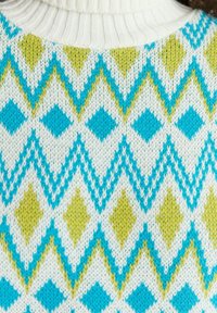 Gebreide trui met een witte basis en turquoise, groene en gele diamantenpatronen. Gestructureerde stof met een geribde halslijn.