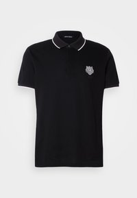 Zwart poloshirt met een contrasterende witte kraag en manchetten. Bevat een tijgerlogo op de linkerborst. Gemaakt van ademend katoen.