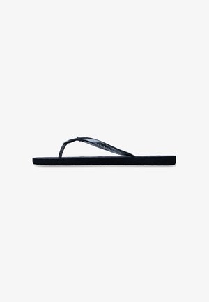 Sandalia plana negra tipo flip-flop con tiras delgadas brillantes en forma de Y y una suela sencilla vista de lado sobre un fondo blanco.