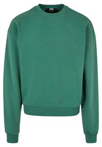 Sweat-shirt en polaire verte avec un col rond, des manches longues, des poignets et un ourlet côtelés. Texture lisse et design minimaliste.