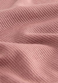 Helehele roosa soonik kangas pehme tekstuuriga, millel on lainelised mustrid ja õrn läige. Materjal näib olevat elastne ja sile.