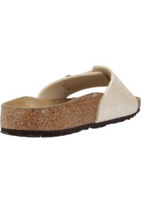 Sandale à semelle en liège avec une tige en cuir beige, présentant un design incurvé et une large sangle, mettant en avant une texture lisse et un profil bas.