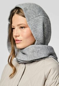 Grå strikket hætte-scarf med ribbet tekstur, svøbt omkring halsen, parret med en lysefarvet quiltet jakke.