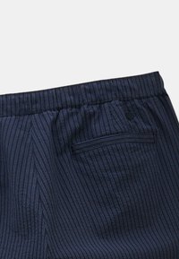Pantalon rayé bleu marine avec taille élastique, doté d'une poche arrière et d'une texture en coton lisse.