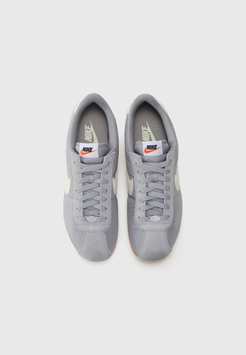 Graue Wildleder-Sneaker mit weißen Akzenten, Schnürverschluss und Gummisohle. Verfügt über einen gepolsterten Kragen und eine gebrandete Zunge.