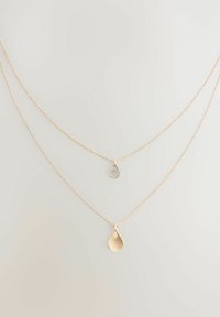 Guldtonade lagerhalsband med en diamant-accentuerad tårpendant och en borstad tårpendant, båda på fina kedjor.