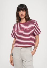 Cropped gestreepte t-shirt in bordeauxrood en wit, met het "MICHAEL KORS" logo aan de voorkant. Gemaakt van zachte stof met een ronde hals.
