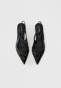Mustat nahkaiset slingback-kengät, joissa on terävä kärki, rypytetty yksityiskohta avauksessa ja sileä, matta pinta. Brändilogo näkyvissä sisäpuolella.