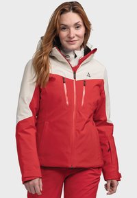 Red and cream waterproof jacket with a hood, zippers, and pockets. Features a sporty design and durable fabric for outdoor activities.