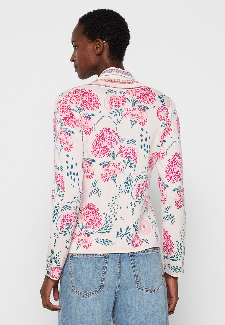 Trui met bloemenpatroon in zachte stof, met roze en teal bloemen op een lichte achtergrond. Lange mouwen en een kraagdetail.