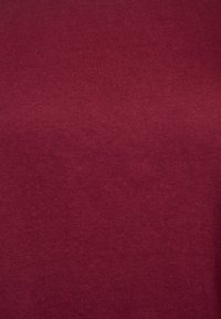 Trdna maroonska tkanina tekstura z drobnim pletenim vzorcem in majhnimi variacijami v odtenkih po površini.