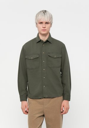 Olive green button-up shirt with two front pockets, long sleeves, a collar, and a relaxed fit. Mildly textured fabric.
