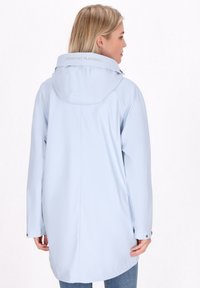 Šviesiai mėlyna nepralaidi vandeniui striukė su kapišonu, turi siuvinėtus akcentus ir užrašą gale. Ilgos rankovės su snapų sagomis.