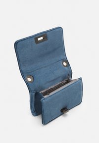 Blå tygplånbok med en strömlinjeformad design, som har tryckknappslås och inre fack, inklusive en dragkedjefack och två cirkulära fästen.