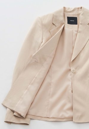 Beige blazer van gladde stof. Hij heeft een reverskraag, een sluiting met één knoop en een satijnen binnenvoering.