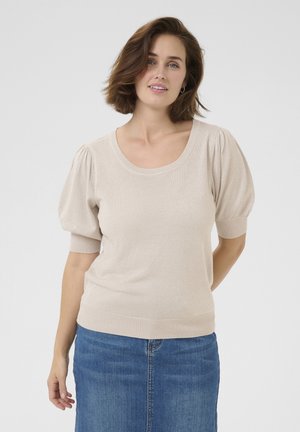 Beige, lyhythihainen neulepaita, jossa on pyöreä pääntie ja puffihihat. Paita on hienostuneesti kiiltävä ja siinä on tiukka alahelma. Denim-hame näkyy alla.