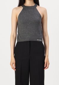 Grå halterneck crop top med en figursydd design, med små pärlor utspridda över tyget. Matchad med svarta högmidjade byxor.