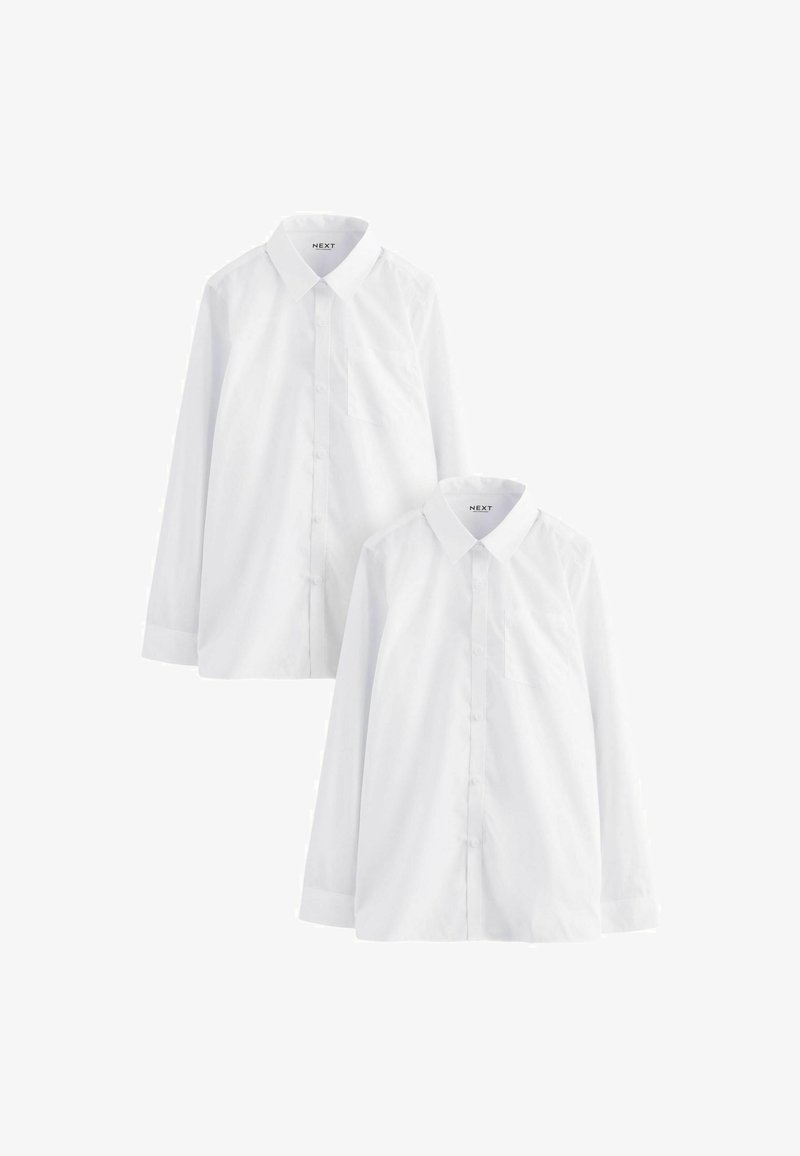 Deux chemises blanches unies à manches longues avec col et boutons, l'une légèrement derrière et au-dessus de l'autre, sur fond blanc.