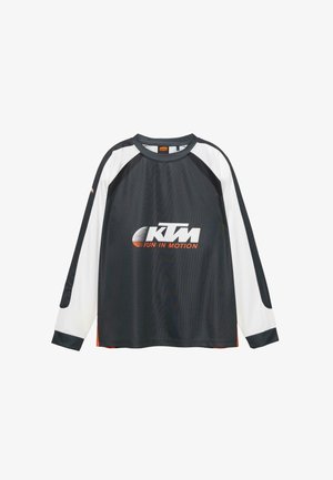 Camicia a maniche lunghe in bianco e nero con colletto tondo. Presenta il logo "KTM" in testo bianco e arancione. Realizzata in tessuto liscio e leggero.