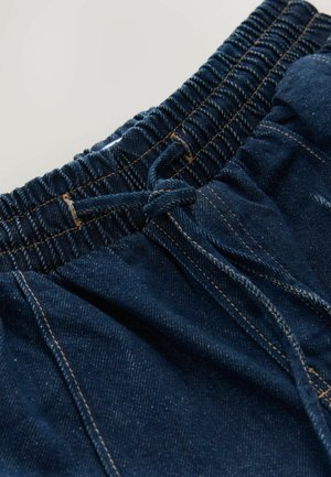 Džinsiniai šortai su elastingu juosmeniu, tamsiai mėlynos spalvos audinys ir matoma siuvimo detalė. Savybė - priekinis raištis, leidžiantis reguliuoti dydį.