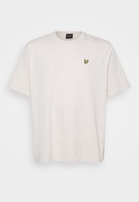 T-shirt en coton blanc à manches courtes, arborant un petit logo d'oiseau jaune sur la poitrine gauche. Design simple et classique.