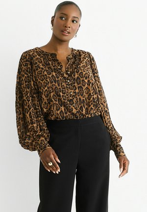 Brown and black leopard print blouse with a buttoned neckline, long puff sleeves, and light, flowing fabric, paired with black pants.