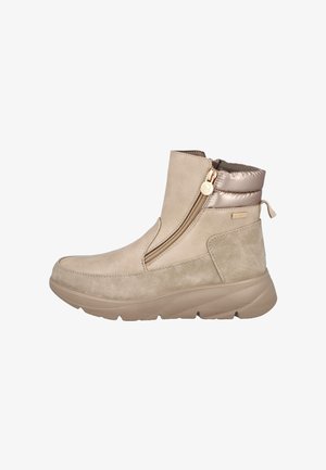 Botín beige con cremallera lateral, cuello acolchado, lazo en el talón y suela de goma gruesa, diseñado para un uso casual.