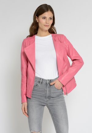 Lyserød lædermotorcykeljakke med et cropped design og asymmetrisk frontlynlås. Kombinationen af en hvid skjorte og grå slidte jeans.