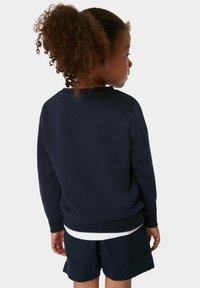Sudadera de color navy con cuello redondo y puños acanalados, combinada con pantalones cortos a juego. La tela parece suave y texturizada.