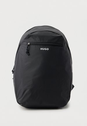 Sac à dos HUGO noir de forme arrondie, avec une poignée de transport sur le dessus, une poche avant zippée et des bretelles rembourrées.