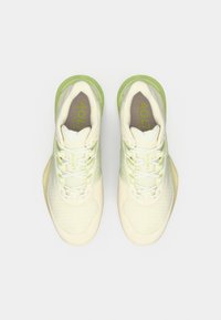 Αθλητικά παπούτσια Lacoste σε κρεμ χρώμα με ανοιχτοπράσινες λεπτομέρειες. Διαθέτουν υφασμάτινο επάνω μέρος με υφή, σχέδιο με κορδόνια και λεπτομέρεια λογότυπου στη γλώσσα του παπουτσιού.