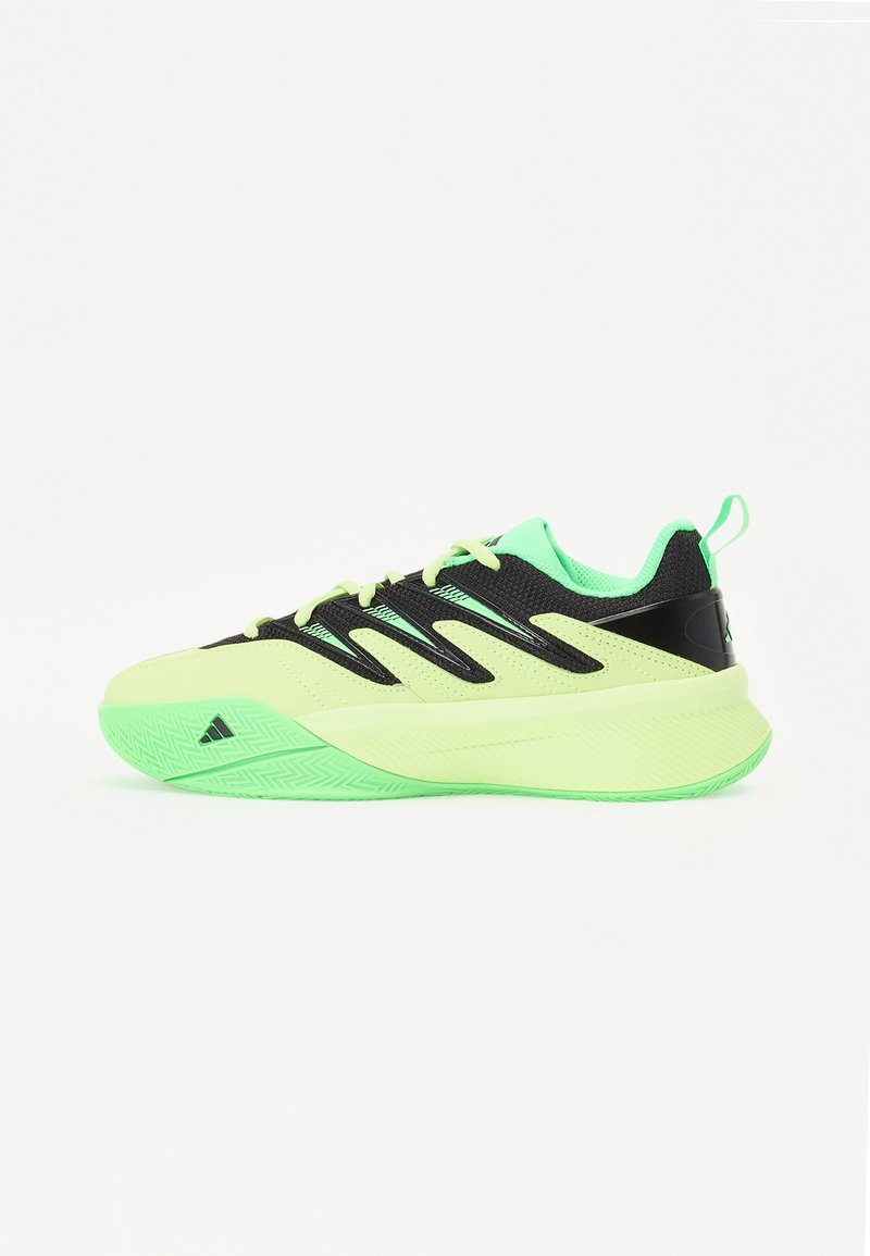 Chaussure de sport noire et vert fluo avec une tige texturée, un système de laçage proéminent et une semelle en caoutchouc présentant un motif en zigzag.