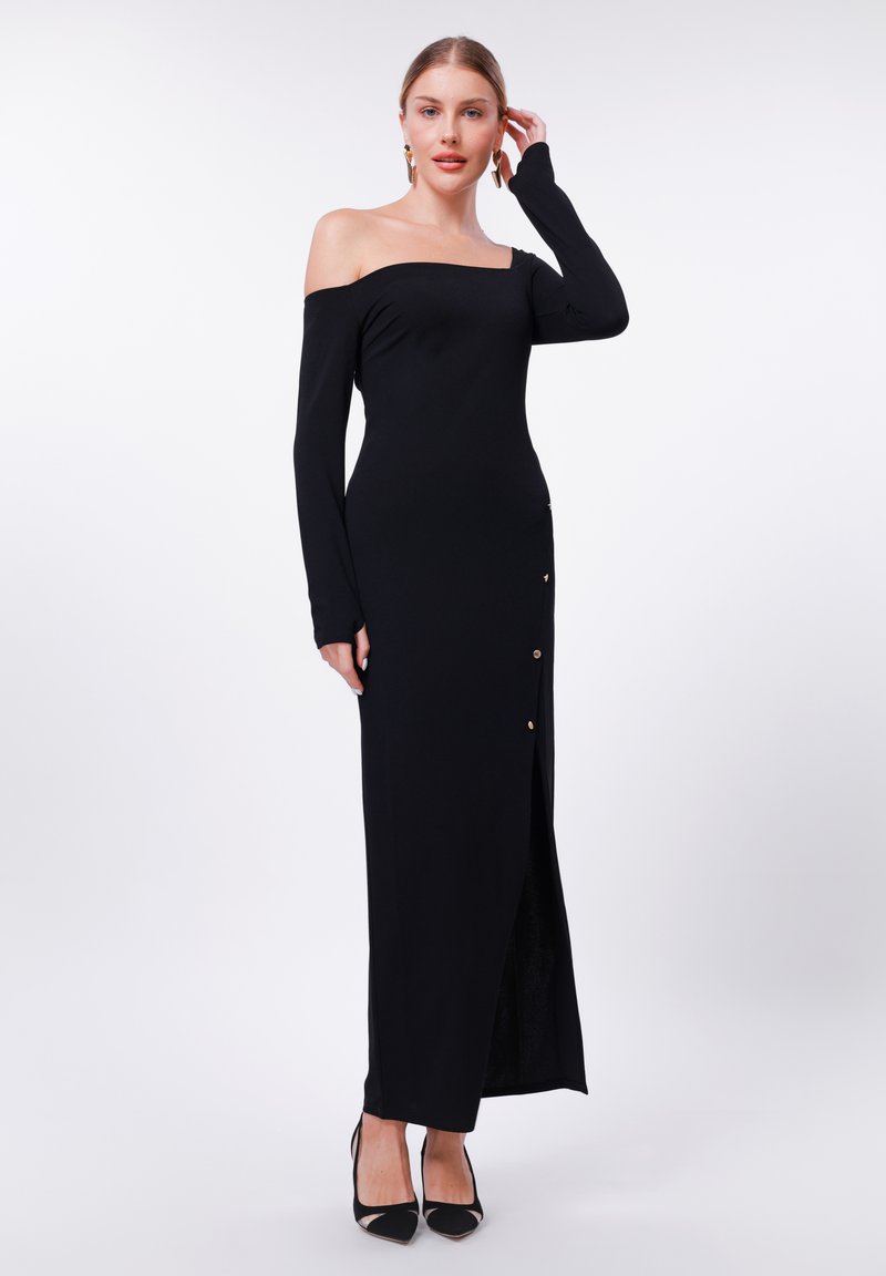 Svart off-the-shoulder kjole med lange ermer, pyntet med en frontsplitt og gullknapper på den ene siden. Glatt, elastisk stoff.