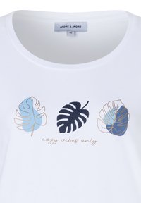Weißes T-Shirt mit drei stilisierten tropischen Blättern in Blau und Marineblau sowie dem Text "Nur gemütliche Vibes" unter den Designs.